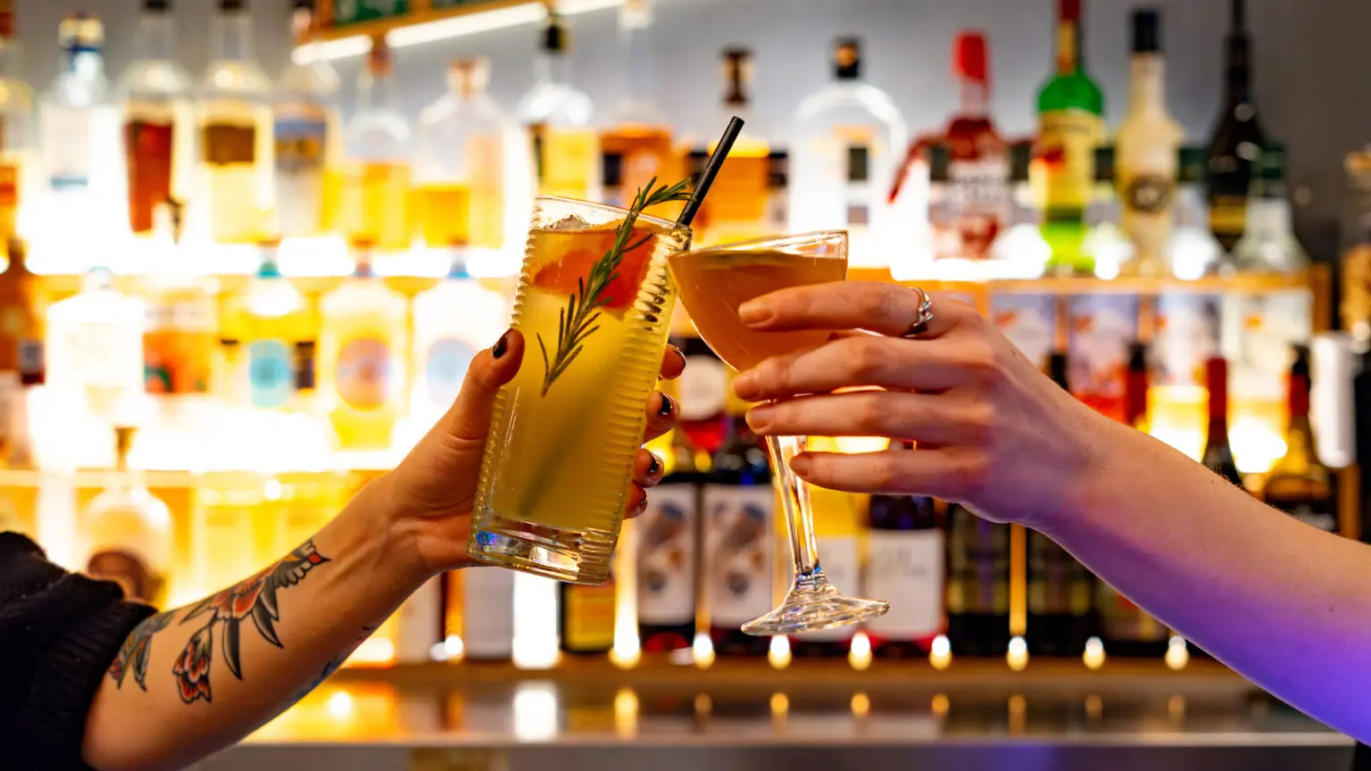 Two people clinking cocktails at North Bar
