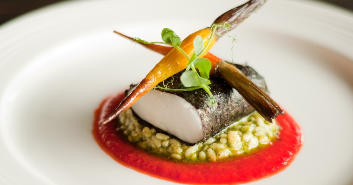 Fine dining fish dish with risotto, red sauce, and carrots