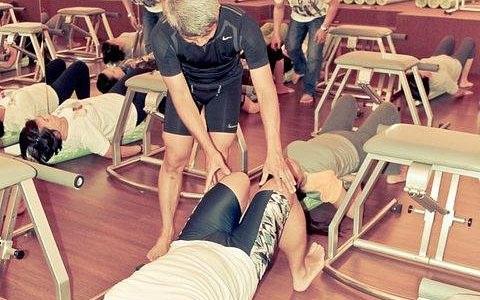 group physical therapy session with instructor assisting
