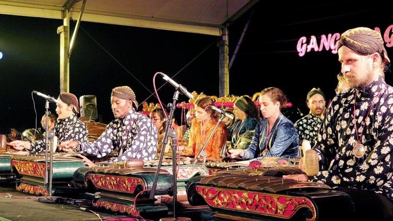 Gamelan ensemble performing on stage with metallophones