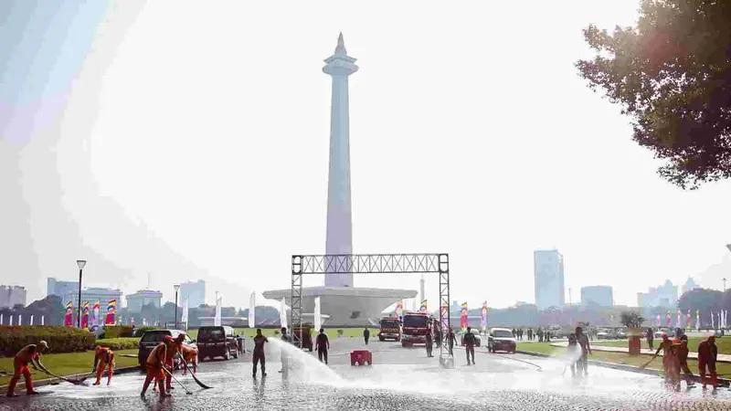 Workers washing plaza in front of Monas monument Jakarta