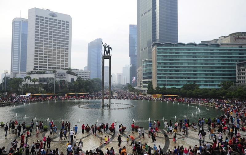 Crowded city fountain plaza with tall skyscrapers