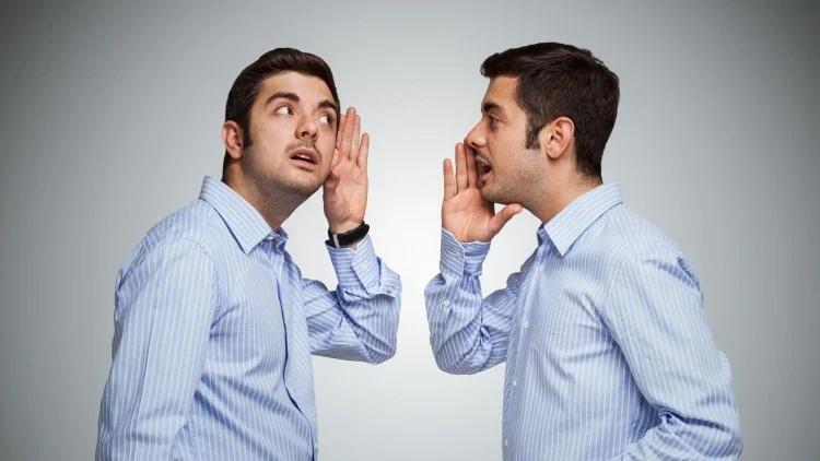 Two identical men whispering to each other