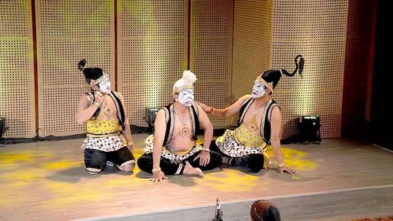 Three traditional masked performers on stage
