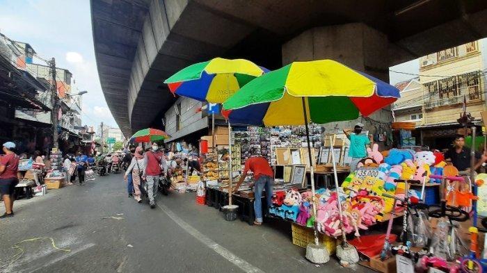 Colorful street market stalls under highway overpass