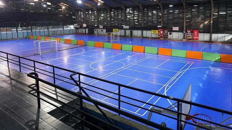 Indoor futsal court with blue floor and goals