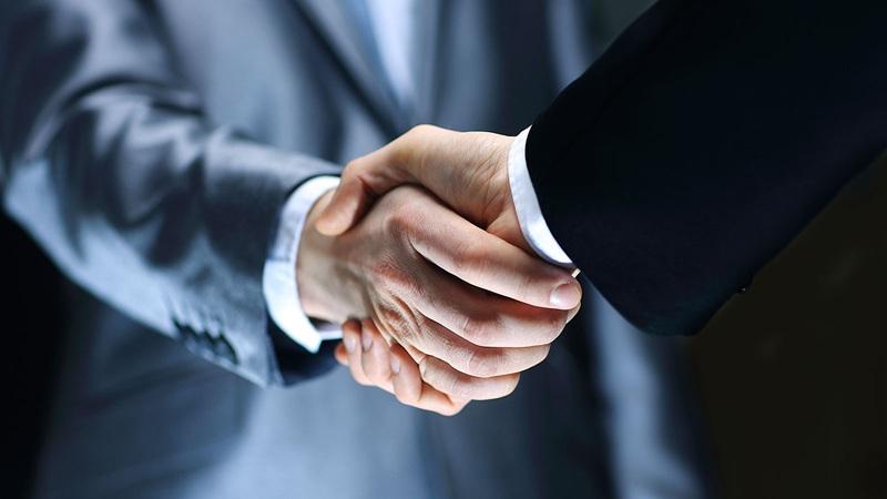 Business handshake between two people in suits
