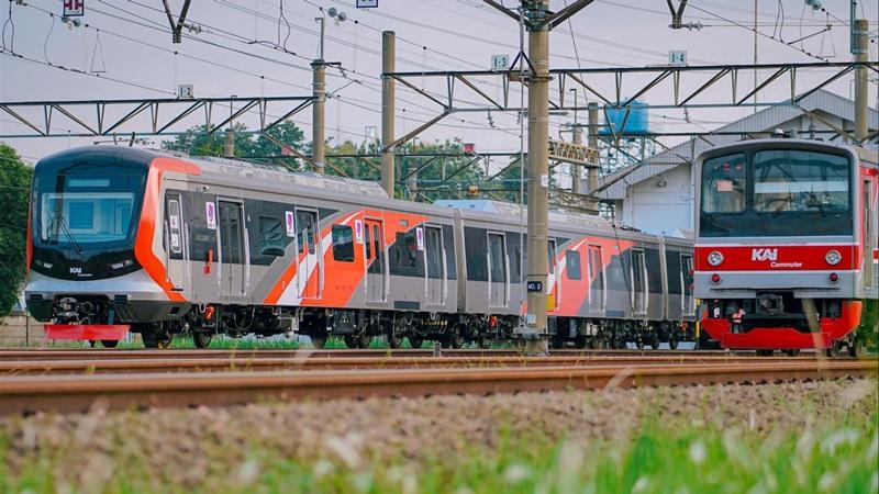 Two commuter trains on tracks under overhead wires