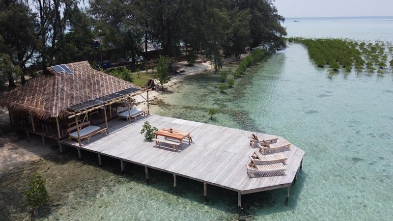 Aerial view of wooden pier with loungers over turquoise sea