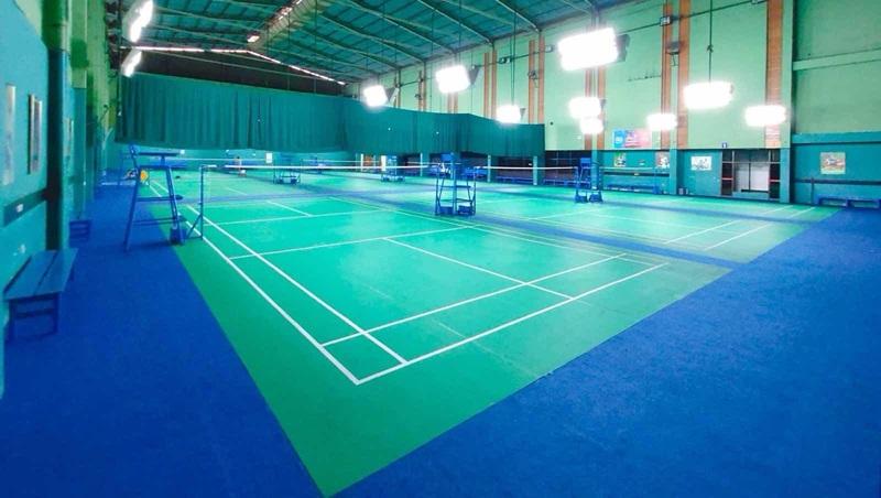 Indoor badminton courts with green and blue flooring