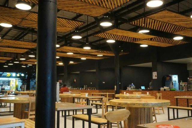 Empty food court with wooden tables and ceiling lights
