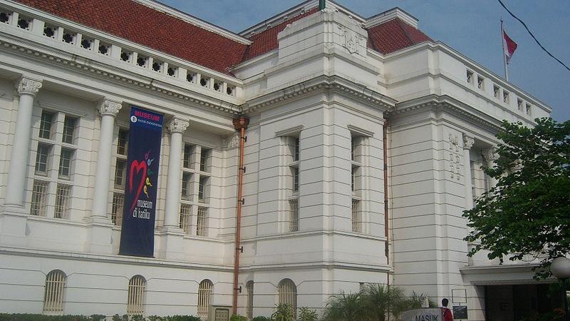 White neoclassical museum building with banner