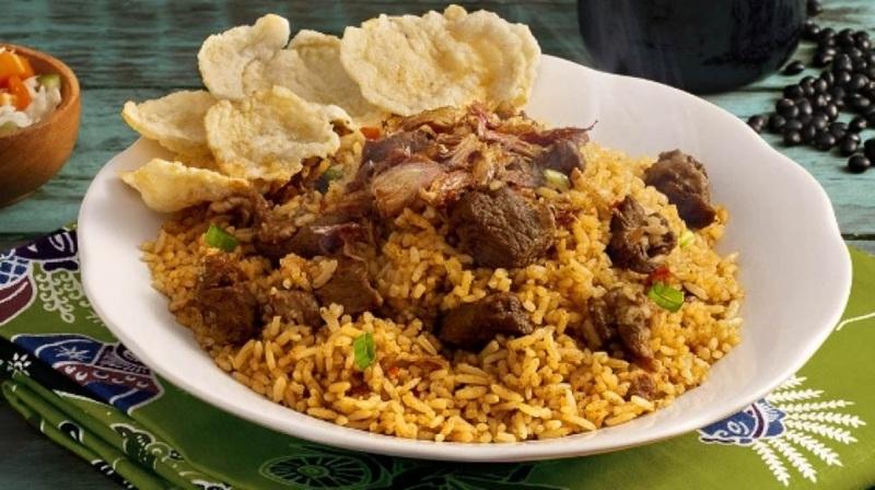 Plate of seasoned rice with beef chunks and crackers