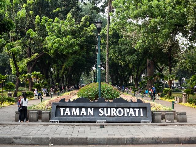 Taman Suropati logo at park entrance with trees