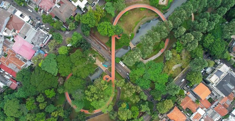 Aerial view of urban park with orange loop bridge