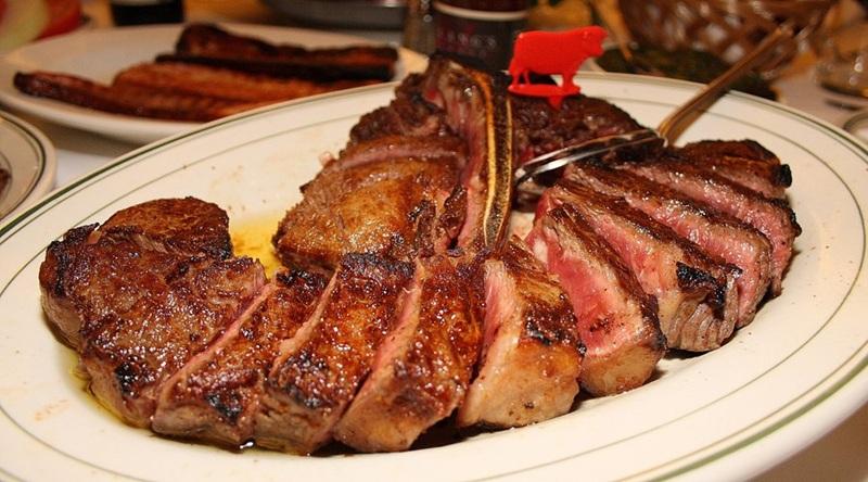 sliced bone-in ribeye steak with red cow marker