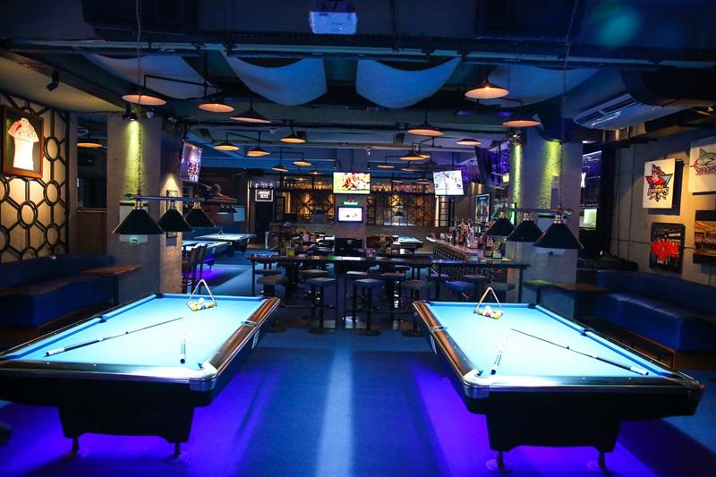Neon-lit billiards bar with two pool tables