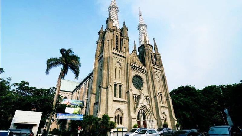 Gothic cathedral with twin spires and palm tree