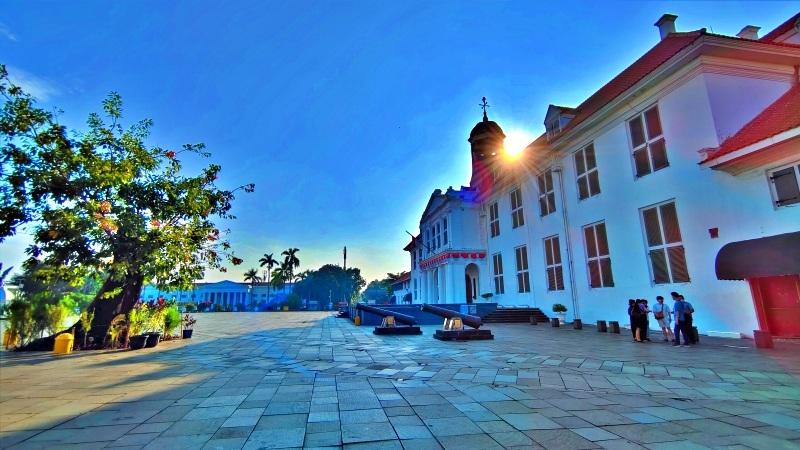 Sunlit colonial white building and cannons on plaza