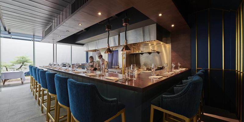 Open kitchen restaurant bar with blue stools