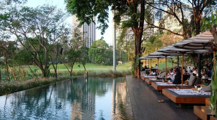 Lakeside cafe terrace with umbrellas and reflecting pool