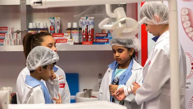 Kids in dental clinic roleplay with Colgate products