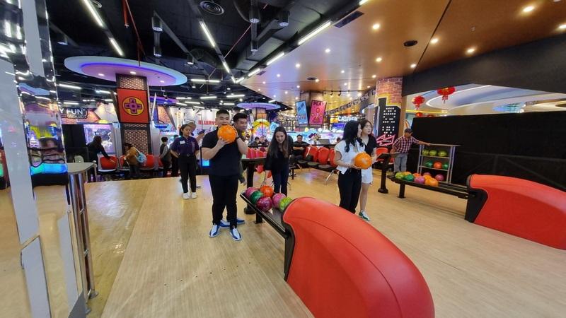 Group of friends bowling in colorful arcade alley
