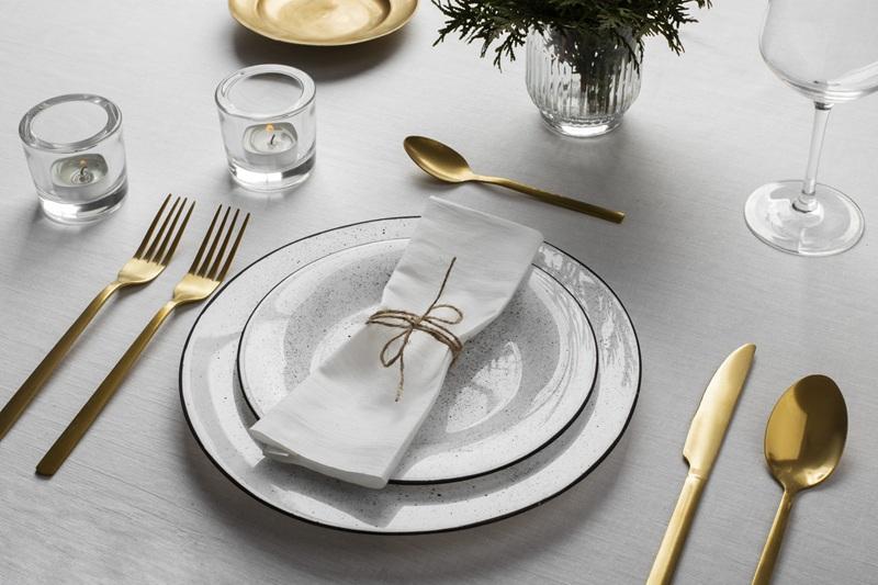 Elegant table setting with white plates and gold cutlery