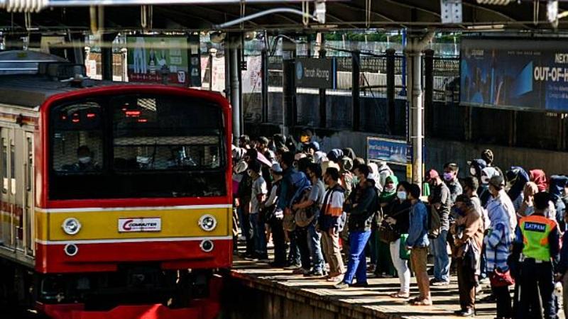 Commuter train arriving at crowded station platform