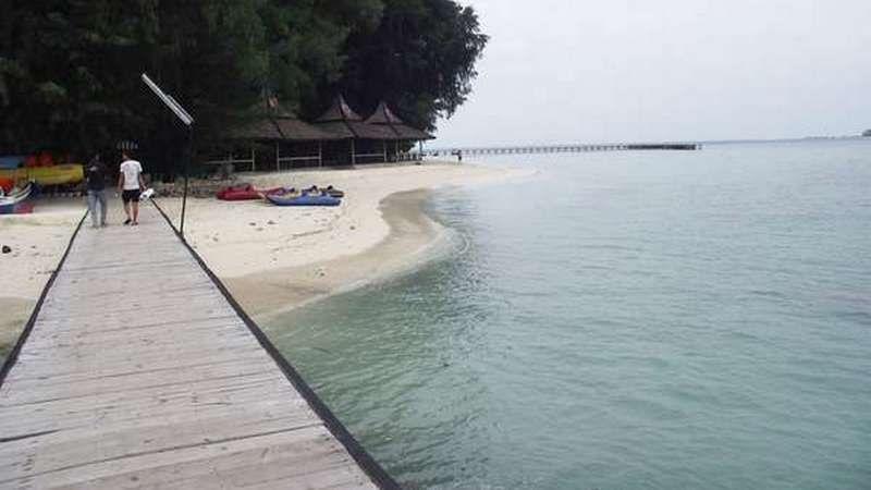 Wooden jetty to tropical beach with kayaks