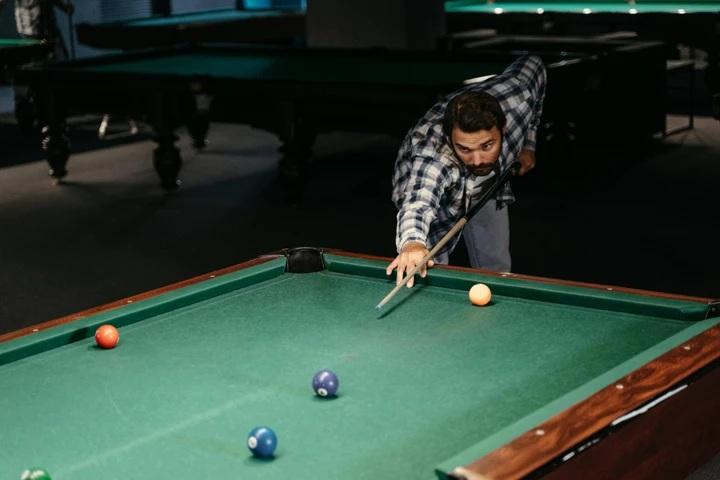 Man aiming shot on pool table