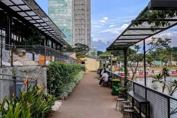 urban riverside promenade with seating and highrise