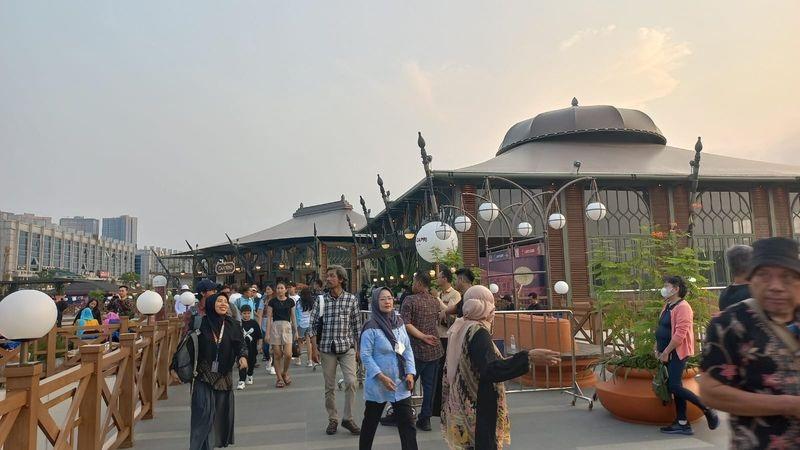 crowded outdoor market walkway with lanterns