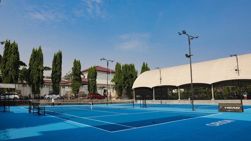 Empty outdoor blue tennis court under clear sky