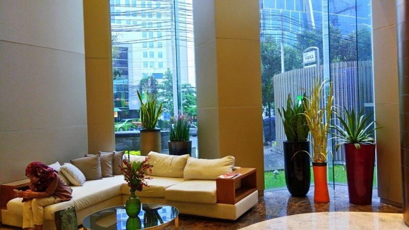 Modern lobby seating with sofa, plants and city view
