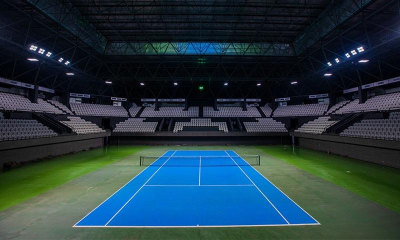 Empty indoor blue tennis court in stadium