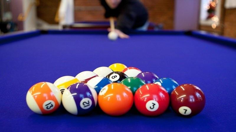 racked pool balls on blue felt table