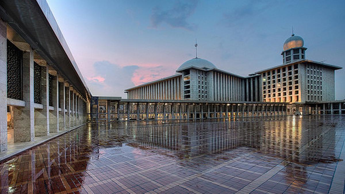 large mosque complex with reflective tiled courtyard at dusk