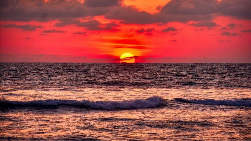 Orange sunset over calm ocean waves