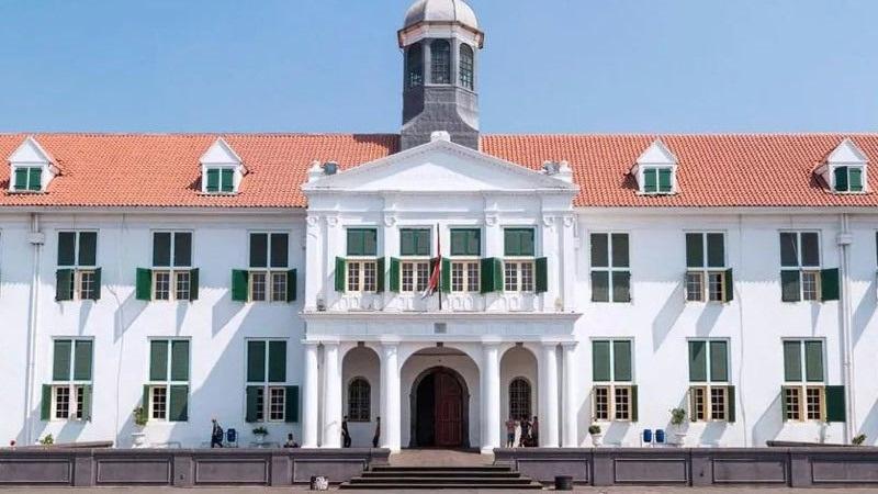 White colonial building with green shutters and dome