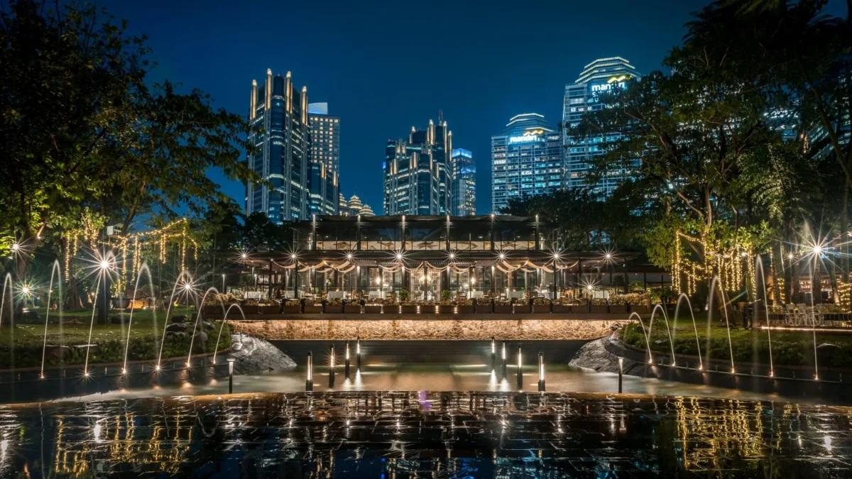 Night waterfront restaurant with fountains and skyline