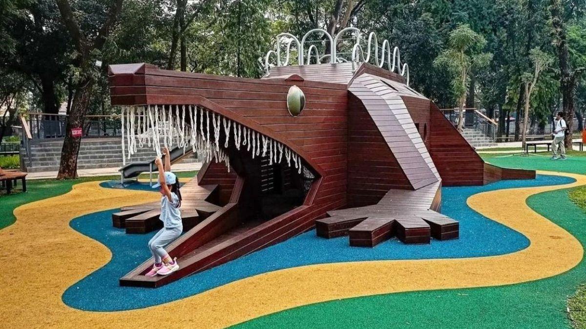 Wooden crocodile playground structure with child