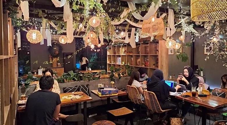 Cozy plant-filled cafe with hanging lights and diners