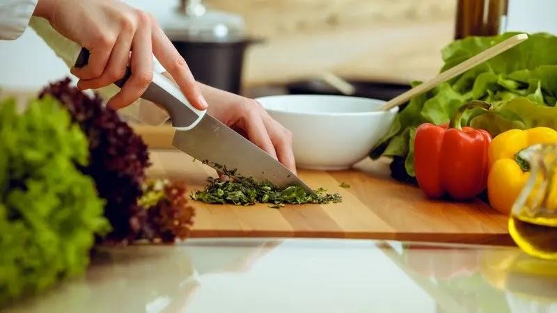 Chopping herbs with colorful bell peppers