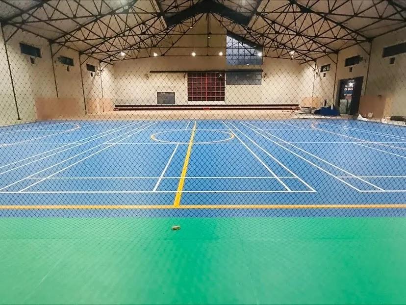 Indoor sports hall blue courts seen through net