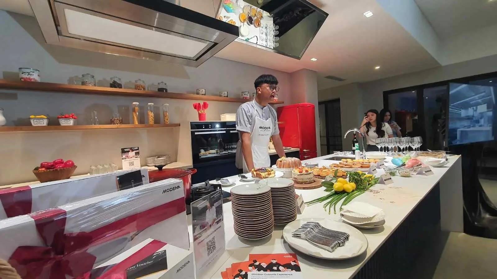 Chef demonstrating cooking at buffet island with pastries