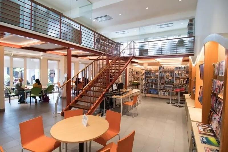 Modern two-level public library interior with staircase