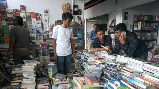 men browsing and selling books in crowded shop