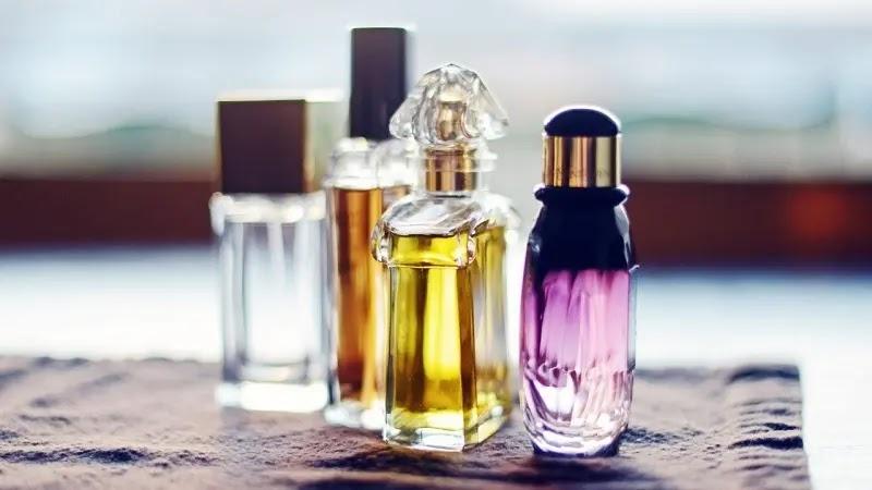 Four perfume bottles with colored liquids on cloth
