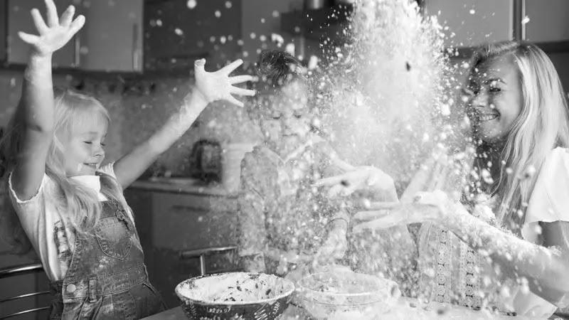 Family baking with flour flying in kitchen